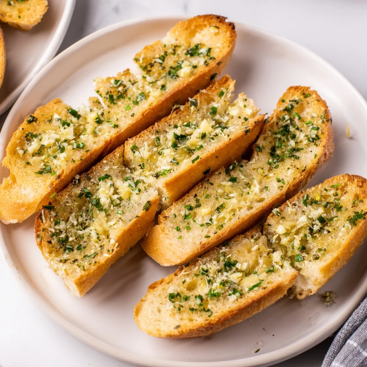 Freshly baked garlic bread, showcasing its rich, herb-infused garlic butter melting on top.