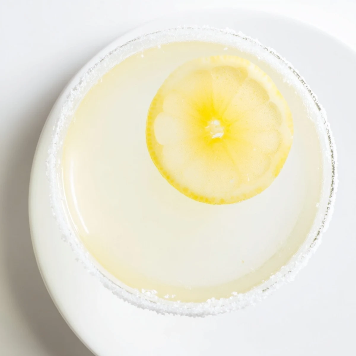 Bright, sunny image: a chilled Lemon Drop cocktail, garnished with a lemon twist, inviting refreshment.