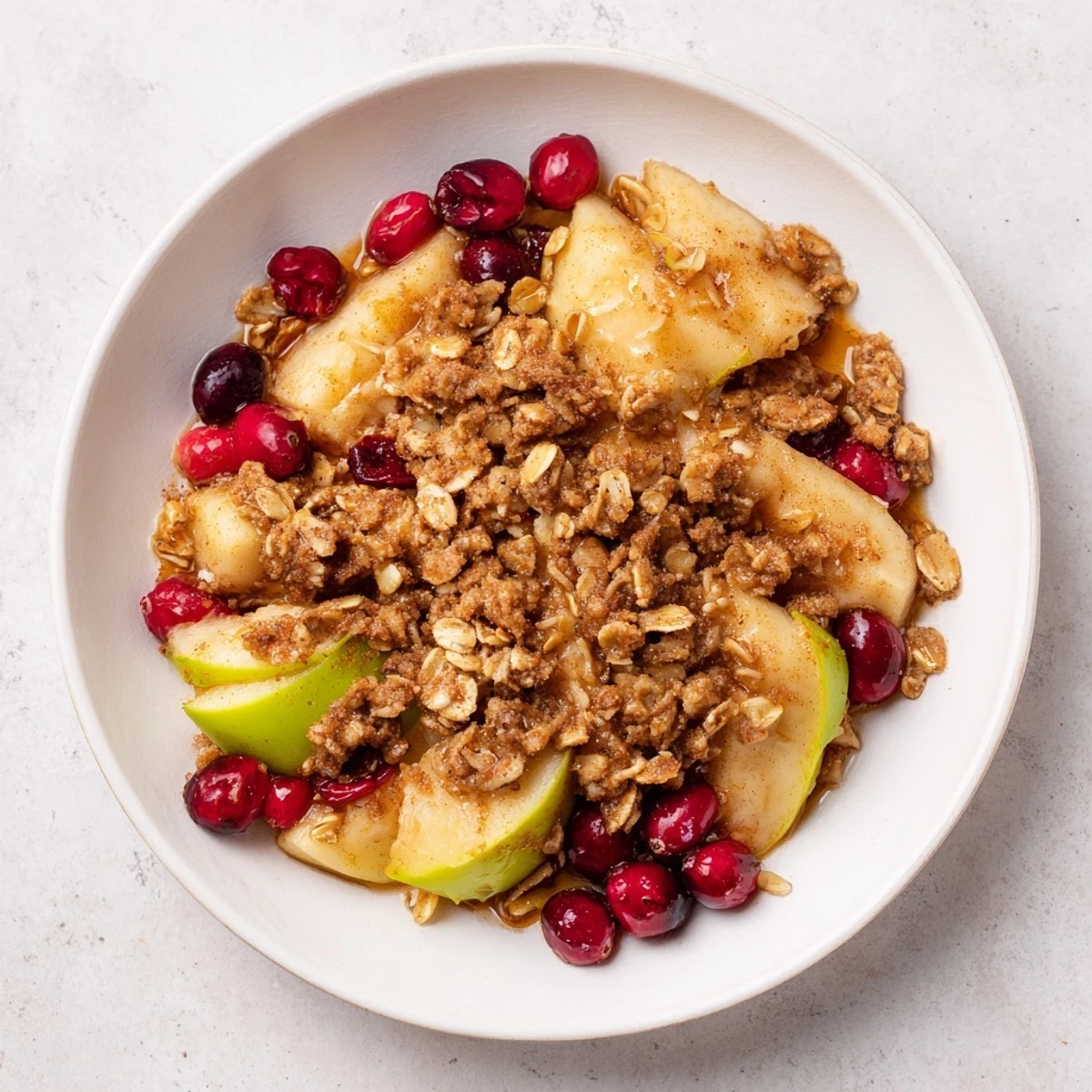 A close-up of a warm Cranberry Apple Crisp with a crisp golden oat topping, perfect dessert.