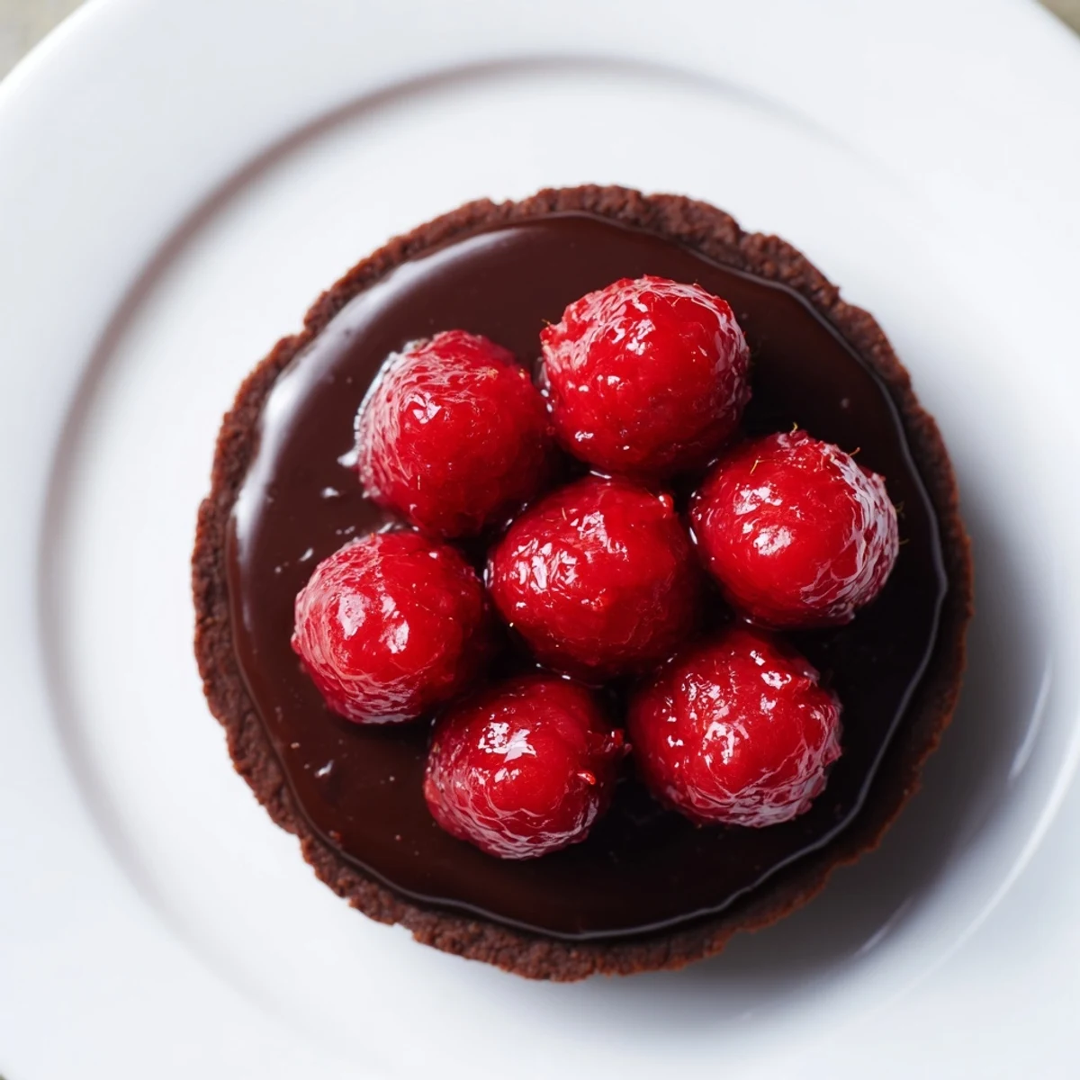 A close-up of a beautifully decorated Chocolate Raspberry Tart with luscious fresh berries.