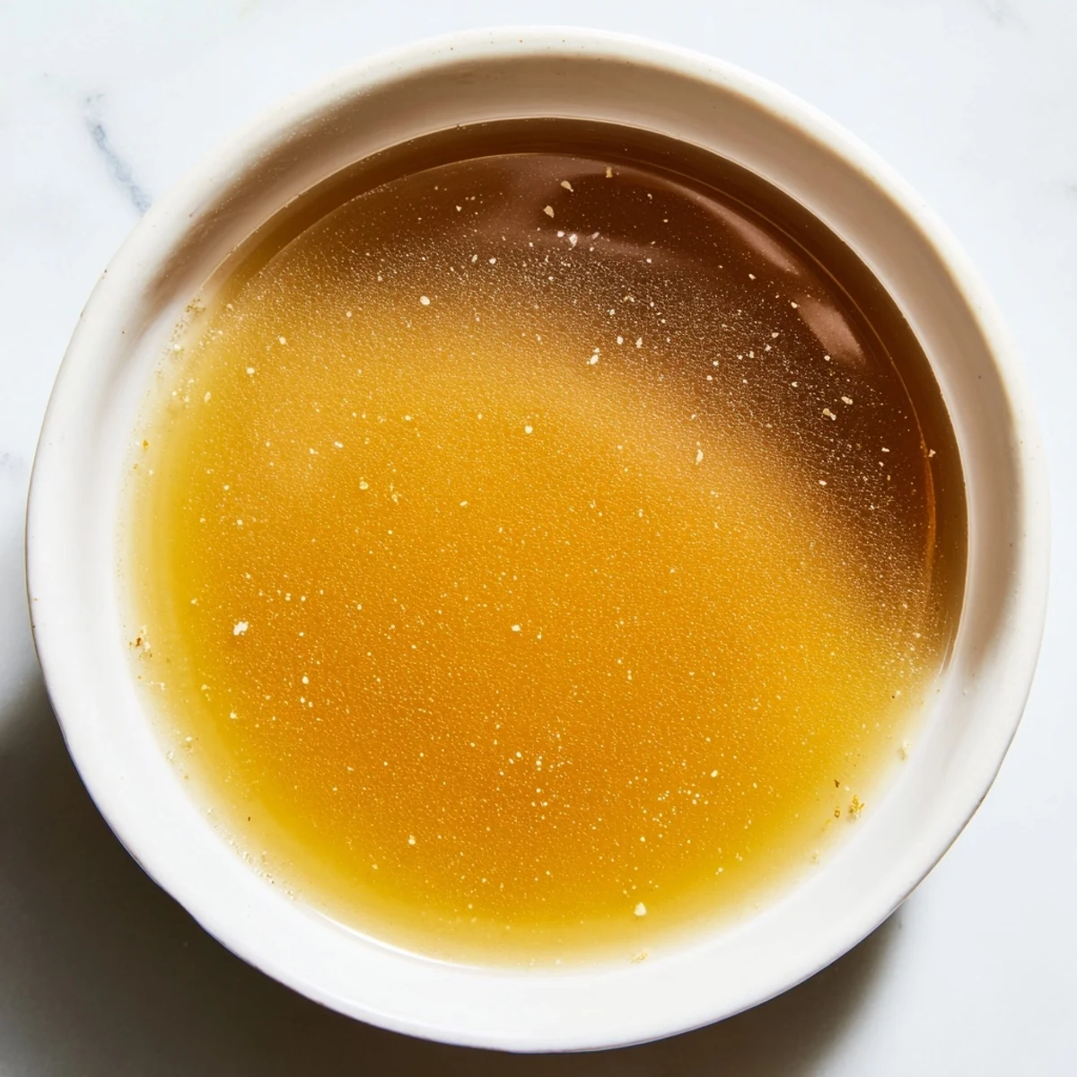 Aromatic roasted vegetables and beef bones simmering for a rich homemade beef stock.