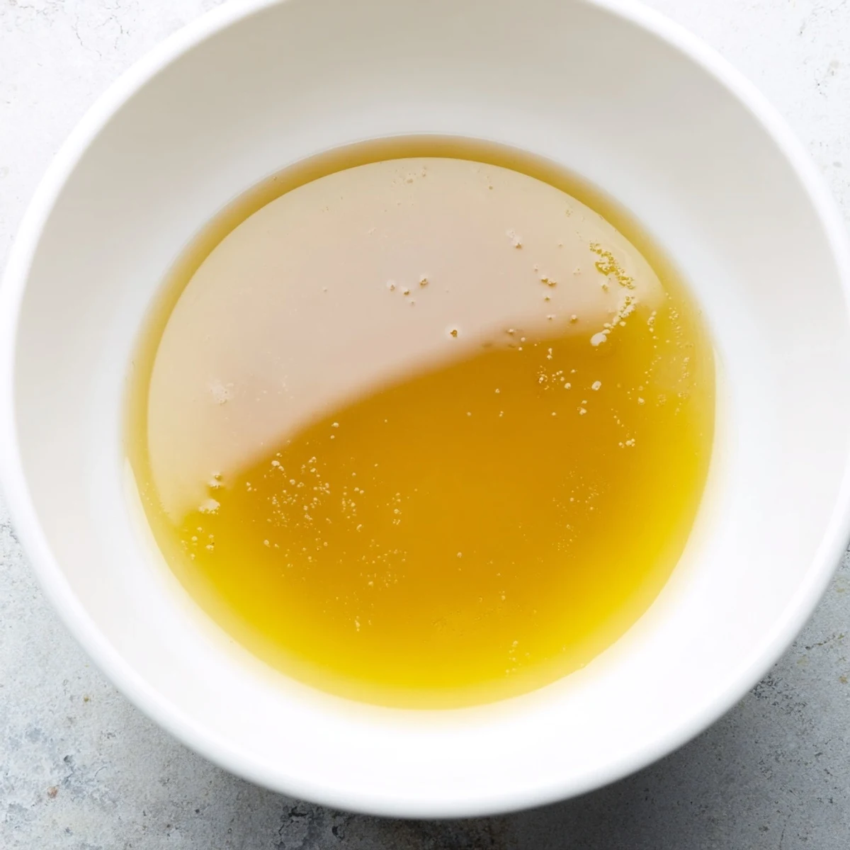 The deep, savory color of freshly strained beef stock, ready to flavor your favorite recipes.