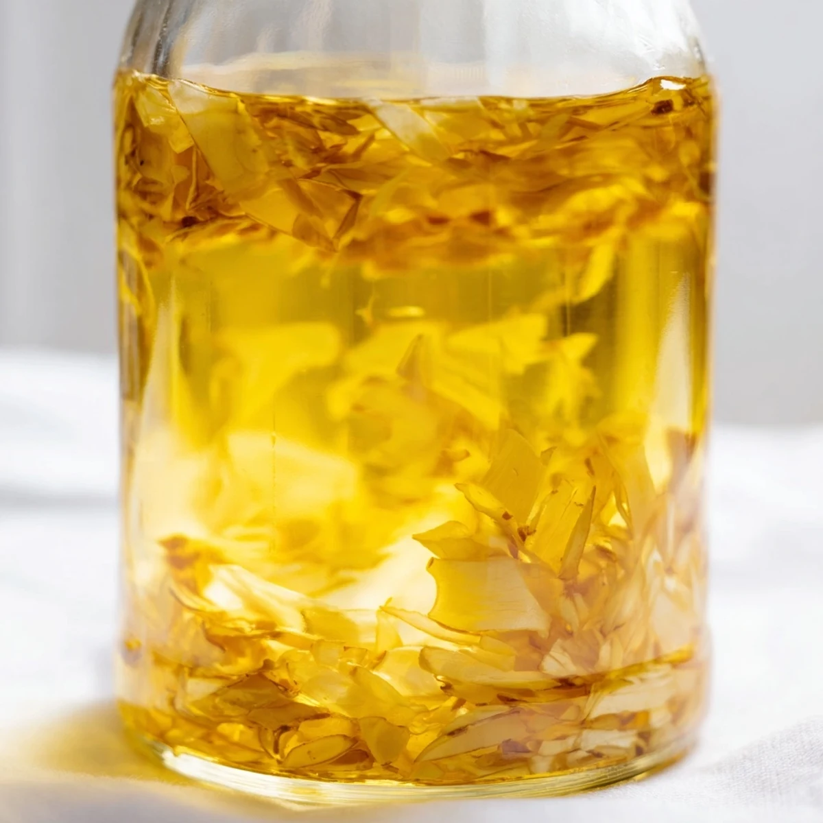 Golden garlic slices gently infuse olive oil, creating flavorful garlic-infused oil for your dishes.