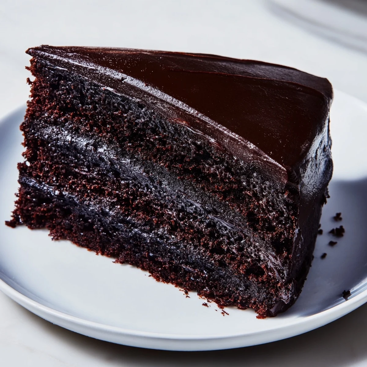 Moist slices of dark chocolate cake, glistening with rich ganache, perfect dessert delight.