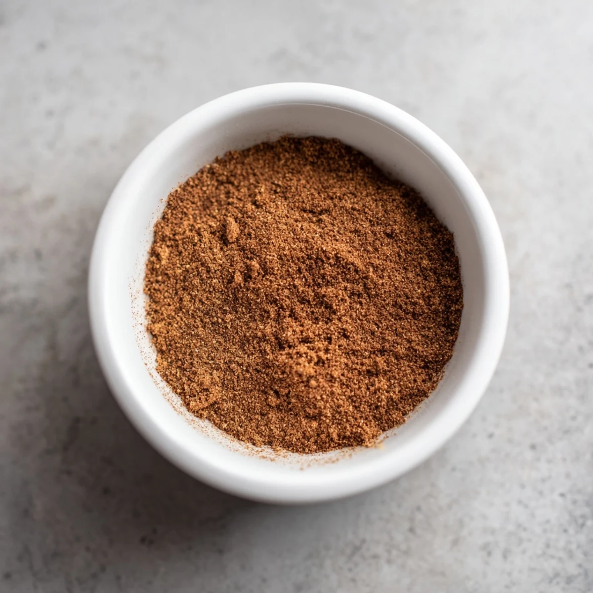 A close-up of a gingerbread spices blend, showing the cinnamon, cloves, and ginger in a bowl.