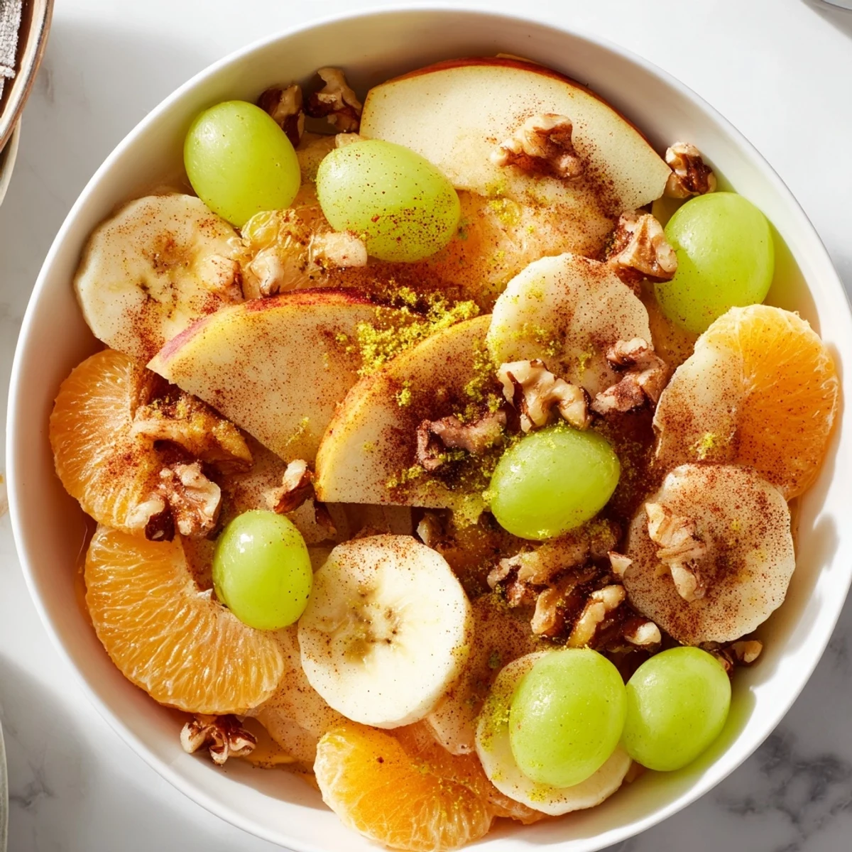 A plate of warm fruit salad, the juicy fruits glistening with honey and spices.