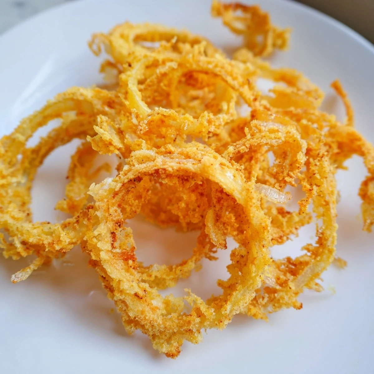 Onions croustillants, croustillants à l'extérieur et tendres au centre, servis chauds avec de la salade.