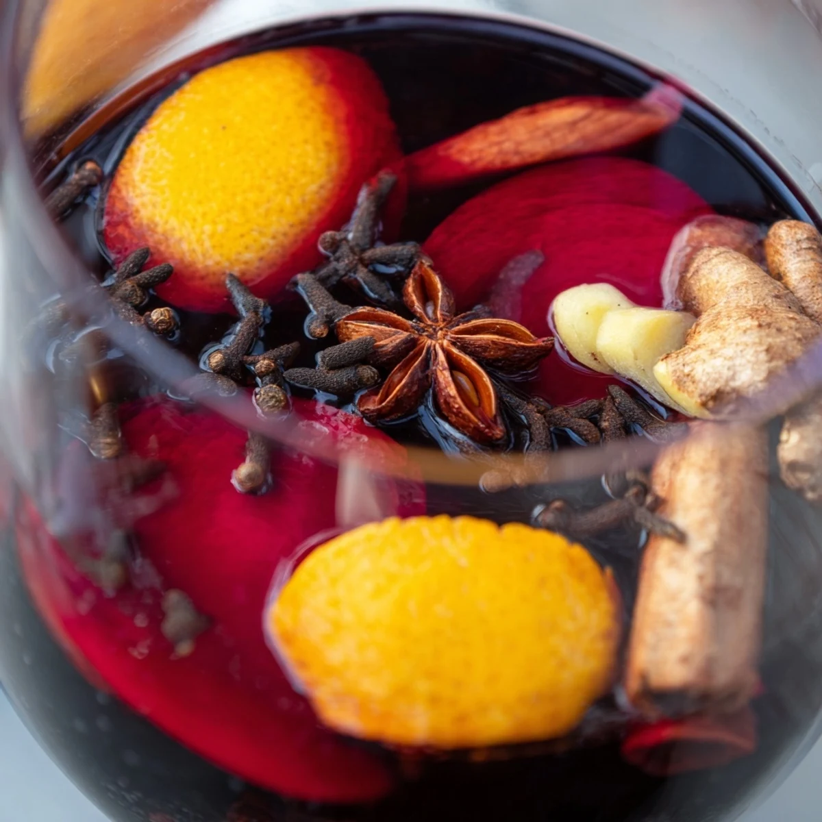 Mugs de vin épicé sans alcool avec zestes d'orange et étoiles d'anis éclatantes.