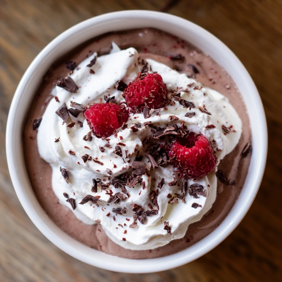 Rich Chocolate Lunch Dessert mousse in glasses topped with fresh berries and chocolate shavings.