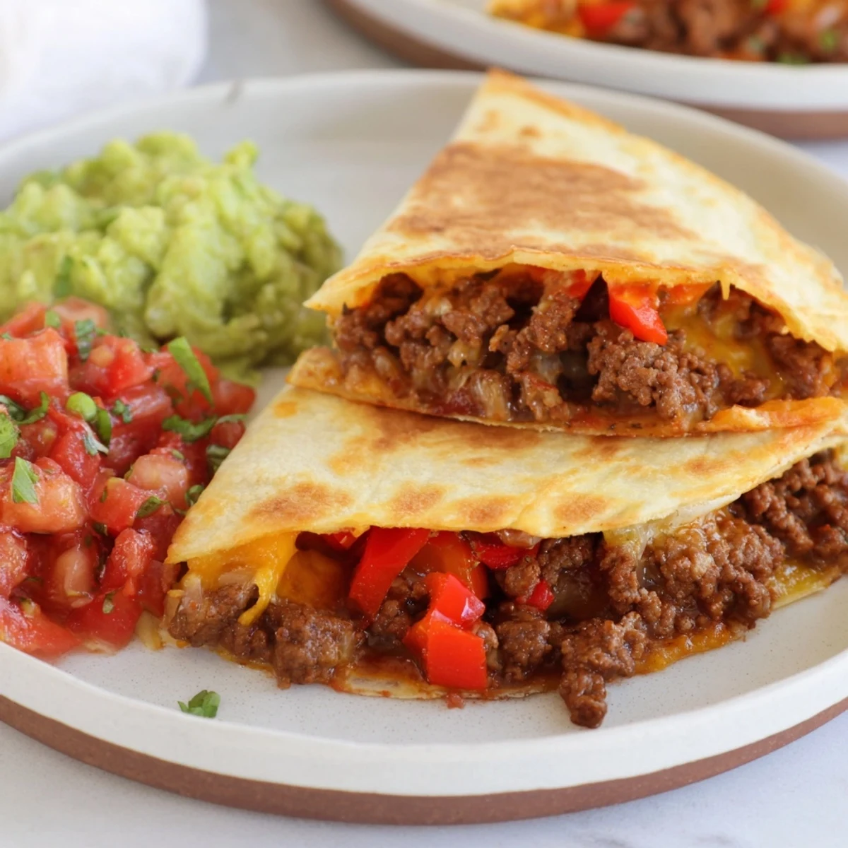 Homemade Flour Tortillas filled with beef and served with Beef Quesadillas with Salsa and Guacamole.
