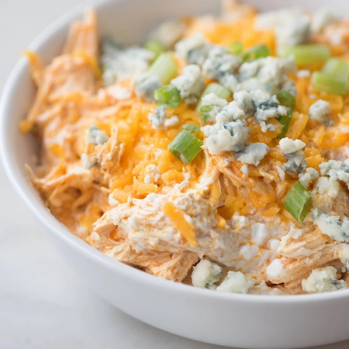 Spicy Buffalo Chicken Dip with Celery and Chips, baked until bubbly, golden, and creamy, served warm for dipping.