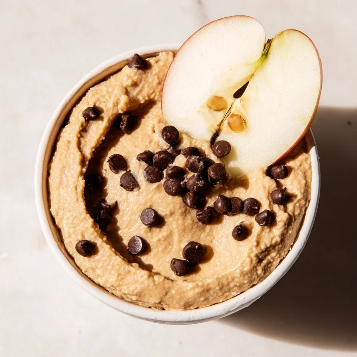 Une collation saine et gourmande présentant une trempette type pâte à cookies avec des morceaux de pommes juteuses