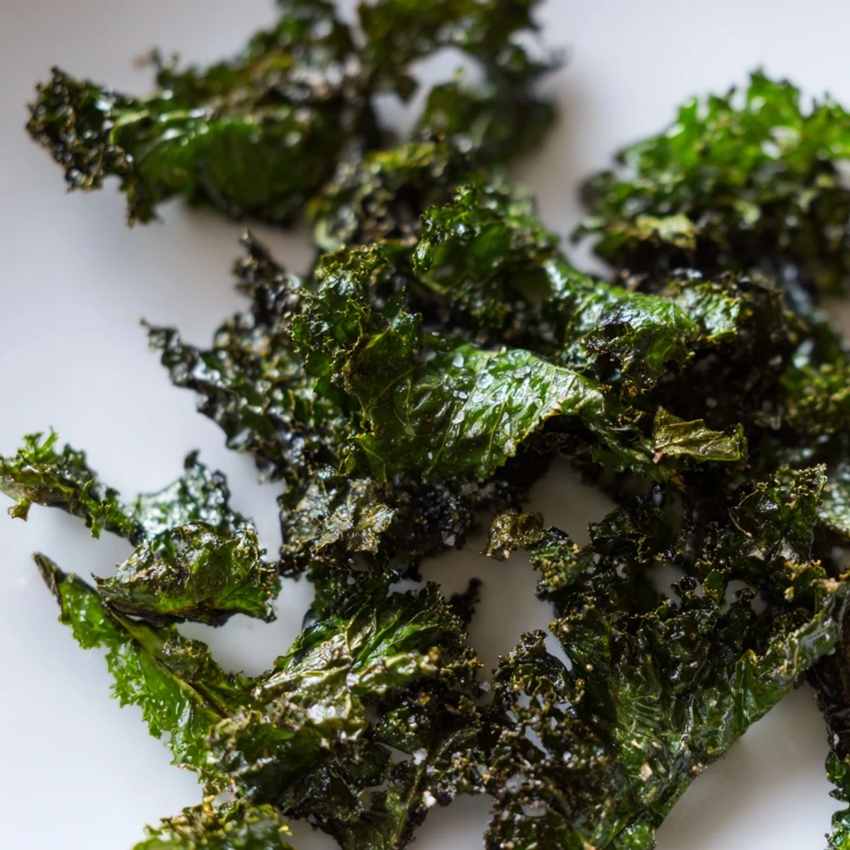Mise en scène de kale chips verts croquants au sel de mer, prêts à déguster dans un bol ceramique chaleureux.