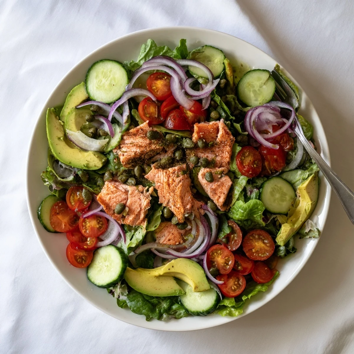 Assiette de Saumon Cuit au Four sur un lit de crudités croquantes, arrosée d'une sauce à l'aneth.