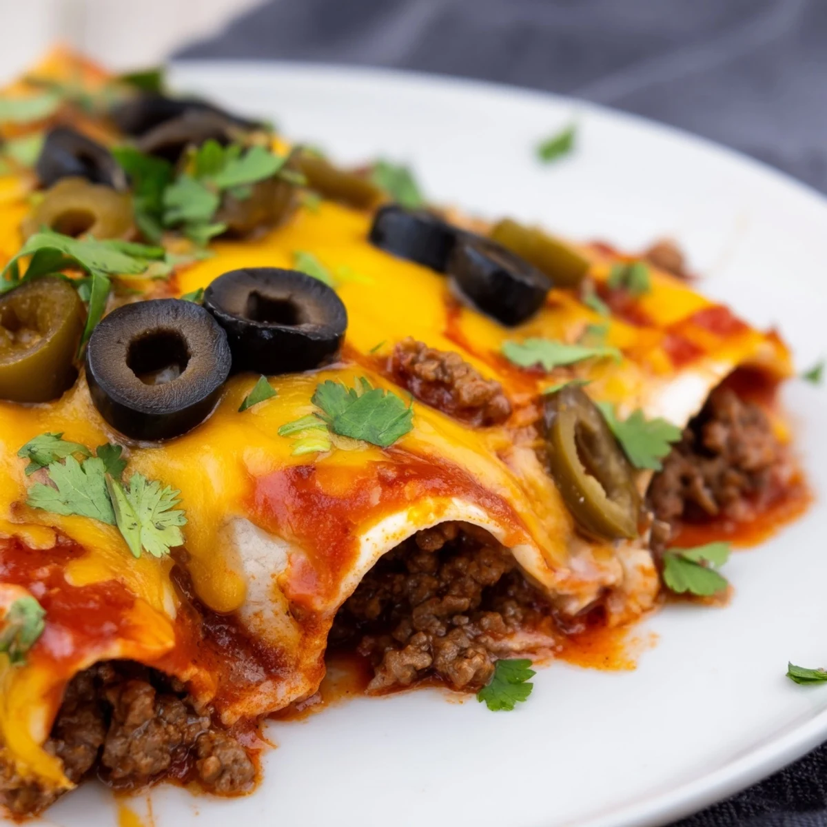 Servez le Beef Enchilada Casserole avec Fromage avec une cuillère de crème fraîche et de la coriandre.