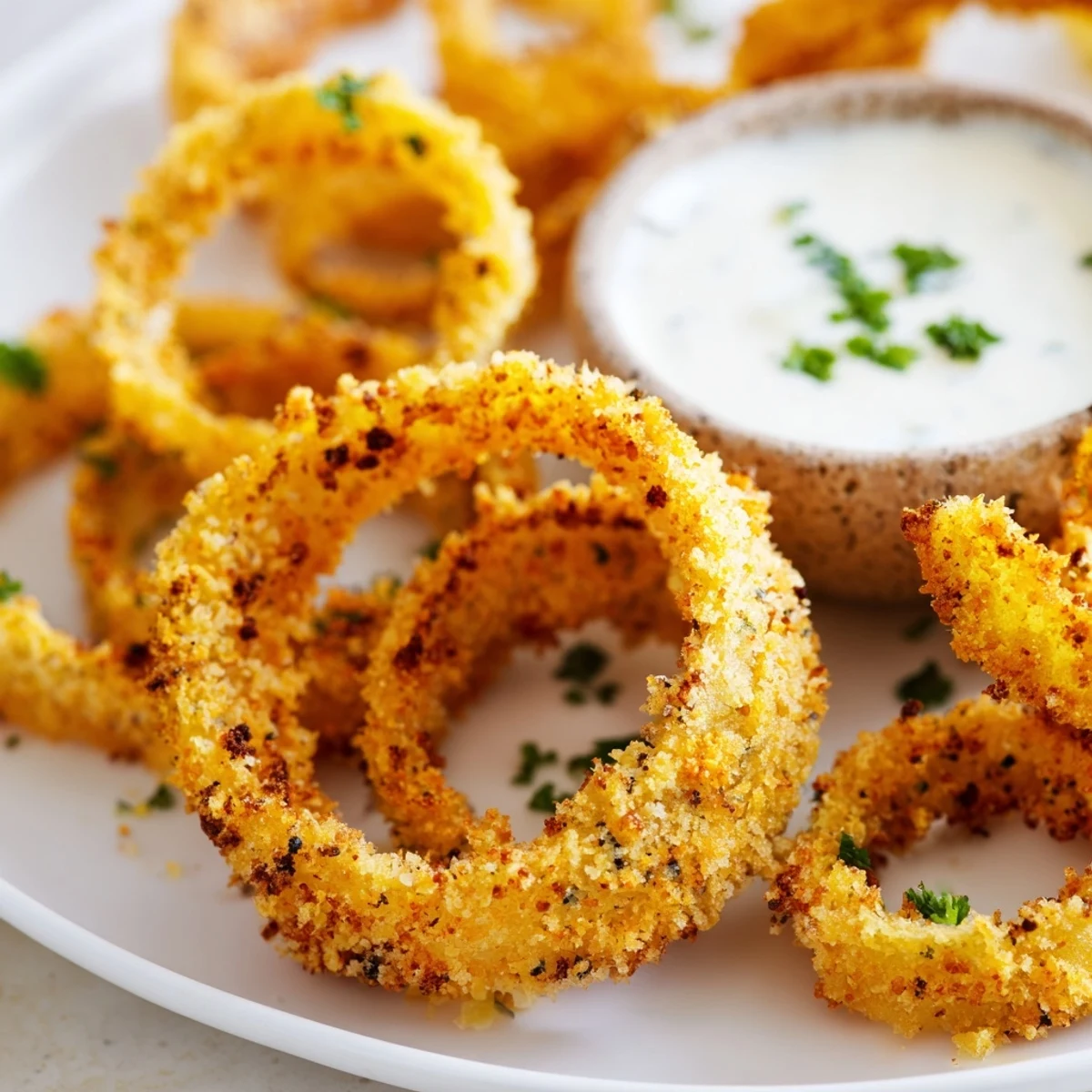 Crispy Baked Onion Rings with Ranch served golden and crunchy on a plate with a side of creamy homemade dip.