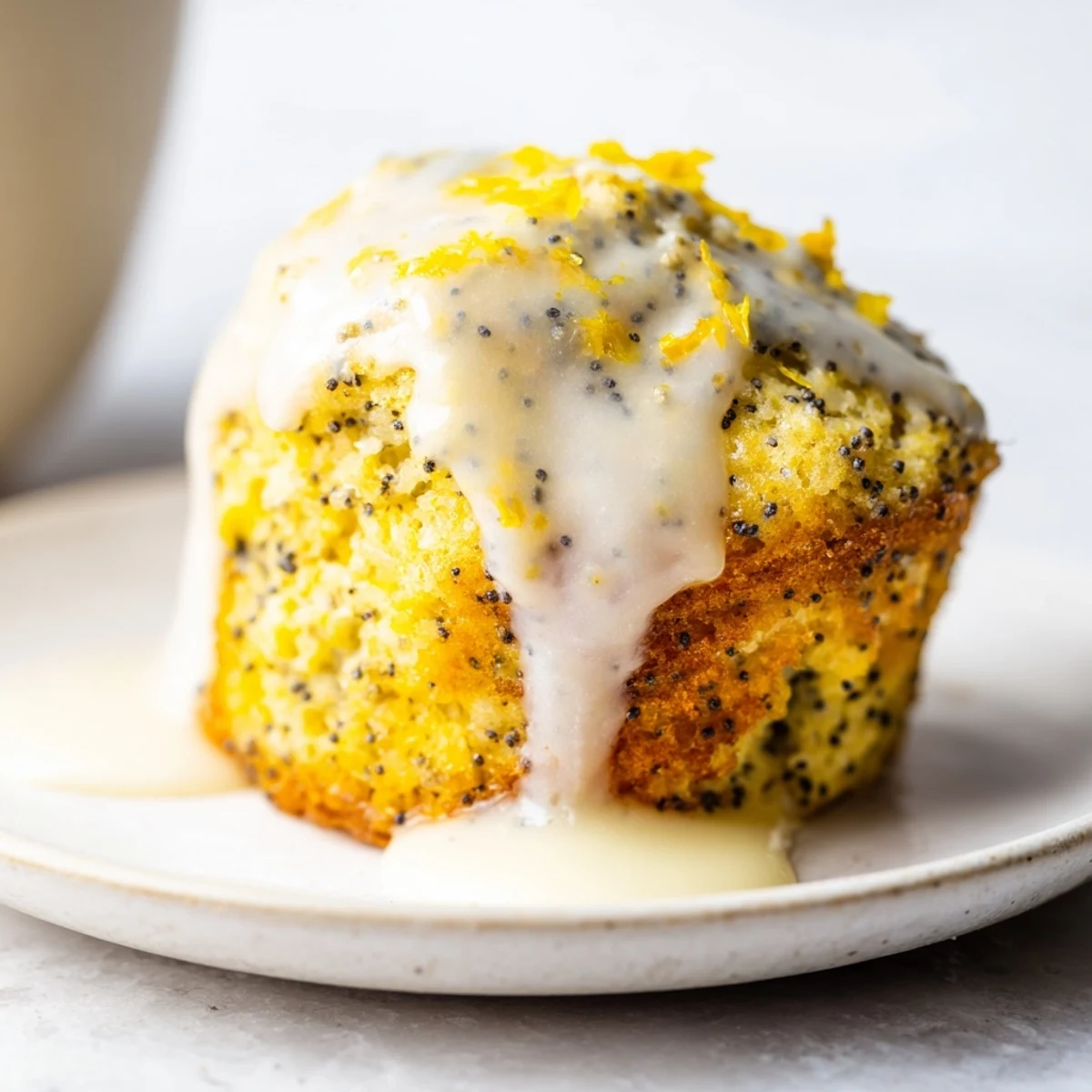 Warm Lemon Poppy Seed Muffins with Glaze drizzled generously with sweet glaze on a cooling rack