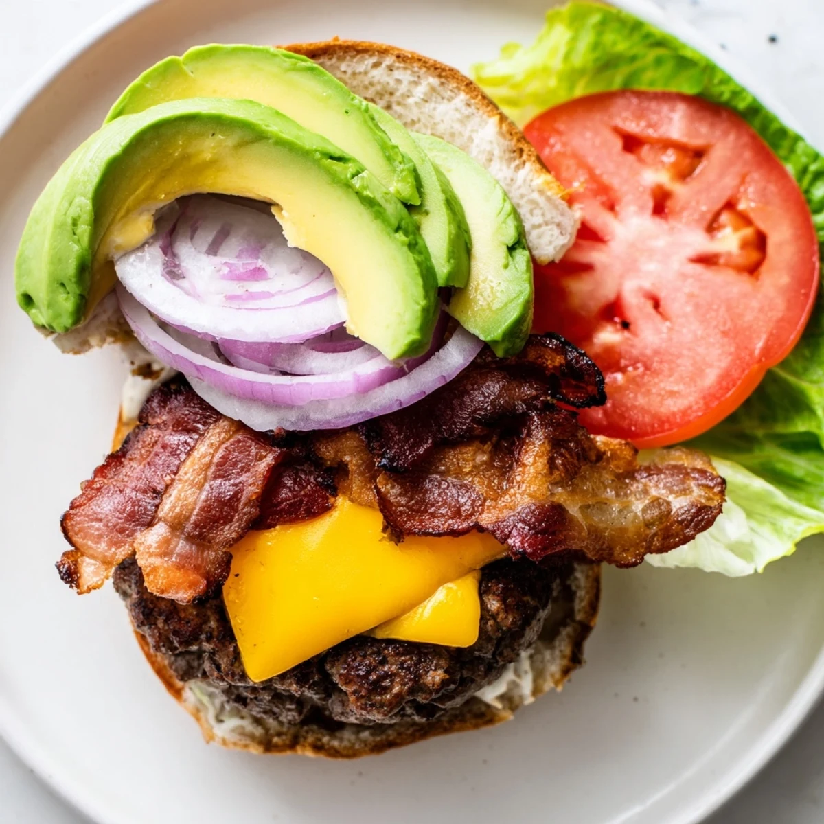 Savoureux burger au bœuf avec avocat et bacon de bœuf servi sur une planche en bois avec garnitures croquantes.