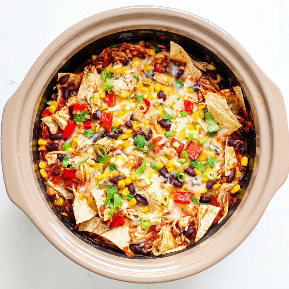 Crockpot Chicken Enchilada Casserole au fromage fondu, servi chaud avec coriandre fraîche et oignons verts