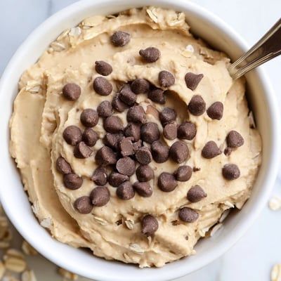 La trempette Chocolate Chip Cookie Dough Hummus sur un plateau d'apéritif avec des pretzels croustillants.