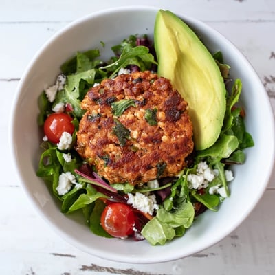 Turkey Burger Salad Bowl présenté comme un plat principal, avec des quartiers de tomates cerises et une vinaigrette onctueuse