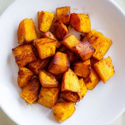 Close-up of tender Roasted Sweet Potatoes with Cinnamon, caramelized edges and a warm aroma, perfect for a holiday table.