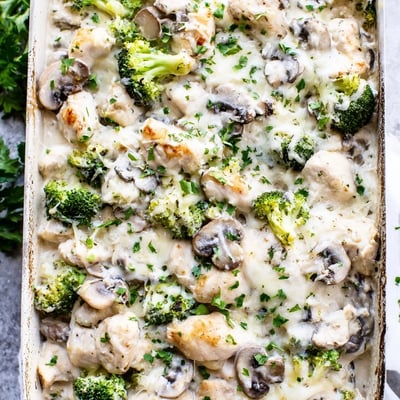 Creamy baked chicken casserole with tender broccoli mushrooms in bubbling cheese sauce